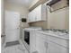 Functional laundry room with white cabinets, modern appliances, and a sink for added convenience at 1734 Summerglow Ln, Monument, CO 80132