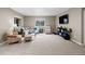 Spacious living room with plush seating, neutral decor, carpeted floors, and a TV entertainment area at 1734 Summerglow Ln, Monument, CO 80132