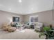 Cozy living room with neutral tones, comfortable seating, and natural light from two large windows at 1734 Summerglow Ln, Monument, CO 80132