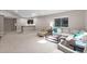 Large living room with bar, plush seating, and ample natural light in basement area at 1734 Summerglow Ln, Monument, CO 80132