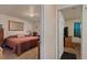 Main bedroom with a large bed, carpet, and access to another room at 220 S Julian St # C, Denver, CO 80219