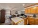 Kitchen with wood cabinets, breakfast bar, and appliances at 220 S Julian St # C, Denver, CO 80219