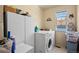 Bright laundry room, washer, dryer, and storage cabinets at 220 S Julian St # C, Denver, CO 80219
