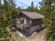 Aerial view of the home with a deck surrounded by lush trees and mountain views at 24 Ski Pole Ct, Breckenridge, CO 80424