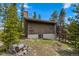 View of back exterior of a home surrounded by trees, and a woodpile for those cold winter nights at 24 Ski Pole Ct, Breckenridge, CO 80424