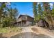 Charming two-story home featuring a spacious deck and a storage shed surrounded by lush trees at 24 Ski Pole Ct, Breckenridge, CO 80424