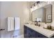Bathroom vanity with navy cabinets, modern fixtures, and a large mirror at 3576 S Holly St, Denver, CO 80237