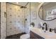 Modern bathroom features geometric tiling, a rainfall showerhead, and updated fixtures at 3576 S Holly St, Denver, CO 80237