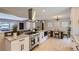 Modern kitchen with granite countertops, stainless steel appliances, open to dining area and living room at 3576 S Holly St, Denver, CO 80237