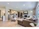 Open-concept living room with hardwood floors, fireplace, and view into the modern white kitchen at 3576 S Holly St, Denver, CO 80237
