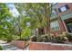 Brick townhome with a well-maintained front yard and mature trees, showcasing a classic architectural style at 2933 Central Park Blvd, Denver, CO 80238