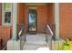 Close-up of the front entrance featuring brick columns, decorative railings, and a welcoming doormat at 2933 Central Park Blvd, Denver, CO 80238