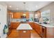 Well-lit kitchen featuring stainless steel appliances, wooden cabinets, backsplash, and a kitchen island at 2933 Central Park Blvd, Denver, CO 80238