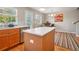 Bright kitchen with wooden cabinets, island, stainless steel appliances, and an open dining area at 2933 Central Park Blvd, Denver, CO 80238