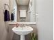 Stylish powder room featuring a pedestal sink, modern fixtures, and attractive wall decor at 2933 Central Park Blvd, Denver, CO 80238