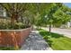 Picturesque street view with tree-lined sidewalk, red brick wall, and attractive landscaping at 2933 Central Park Blvd, Denver, CO 80238