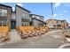 Modern townhome showcasing gray siding, black trim, a walkway and a tidy landscape design, complemented by a blue sky at 9468 W 58Th Ln # B, Arvada, CO 80002