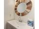 Stylish bathroom vanity with unique, round, reclaimed wood mirror at 8144 Washington St # 192, Denver, CO 80229
