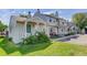 Charming townhome exterior featuring a covered porch, lush lawn, and mature landscaping at 8144 Washington St # 192, Denver, CO 80229
