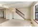 Spacious living area with neutral carpet, a staircase, and ample natural light from a large window at 8144 Washington St # 192, Denver, CO 80229