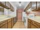 Kitchen with tile floors, stainless appliances, and rustic cabinets and brick accent wall at 15157 E Louisiana Dr # A, Aurora, CO 80012