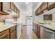 Galley kitchen featuring matching appliances, light countertops, and wood cabinets at 15157 E Louisiana Dr # A, Aurora, CO 80012