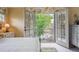 Bedroom view featuring doors opening to a balcony surrounded by lush trees and garden views at 5335 E 2Nd Ave, Denver, CO 80220
