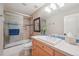 Bathroom featuring a shower-tub combination with blue tile and glass door plus a tile countertop vanity at 5335 E 2Nd Ave, Denver, CO 80220