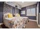 Comfortable bedroom featuring twin beds, patterned wallpaper, and a window letting in natural light at 5335 E 2Nd Ave, Denver, CO 80220