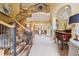 Grand foyer with a curved staircase, elegant chandelier and travertine tile floors at 5335 E 2Nd Ave, Denver, CO 80220