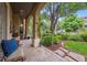 Charming front porch with comfortable seating and a view of the meticulously landscaped yard at 5335 E 2Nd Ave, Denver, CO 80220