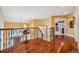 Upstairs hallway with hardwood floors, wrought iron banister and an open view to the kitchen at 5335 E 2Nd Ave, Denver, CO 80220