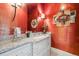 Elegant powder room with vibrant coral walls, granite countertop, and stylish fixtures at 5335 E 2Nd Ave, Denver, CO 80220