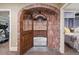 Attractive wine cellar room with arched brick entrance, wood racks, and decorative lighting at 5335 E 2Nd Ave, Denver, CO 80220
