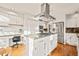 Spacious kitchen with stainless steel appliances, a large island with gas stove, and a built-in desk area at 4534 Palmer Ct, Longmont, CO 80503