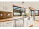 Close up of a kitchen sink with stainless steel appliances, marble countertops, and a window that showcases a beautiful view at 4534 Palmer Ct, Longmont, CO 80503