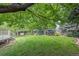 Lush green backyard with a well-maintained lawn, mature trees, and a partial view of a deck area at 9406 Troon Village Way, Lone Tree, CO 80124