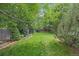 Serene backyard with a lush green lawn, mature trees, decorative landscaping, and a charming brick border at 9406 Troon Village Way, Lone Tree, CO 80124