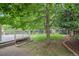 Inviting backyard featuring a spacious deck, lush lawn, mature trees, and charming brick-lined garden beds at 9406 Troon Village Way, Lone Tree, CO 80124
