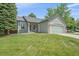 Inviting single-story home featuring a lush green lawn and attached two-car garage at 9406 Troon Village Way, Lone Tree, CO 80124