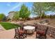 Backyard with a lush lawn, mature trees, and stone retaining walls, creating a serene outdoor space with a fire pit area at 21376 E Union Pl, Aurora, CO 80015