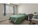Comfortable bedroom with a large window, blue curtains, carpet flooring, and a desk area, perfect for relaxation and study at 21376 E Union Pl, Aurora, CO 80015