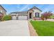 Beautiful home with stone accents, a well-manicured lawn, and a three-car garage at 21376 E Union Pl, Aurora, CO 80015