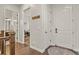 Hallway featuring hardwood floors, multiple doors, coat hooks, and a neutral color scheme at 21376 E Union Pl, Aurora, CO 80015