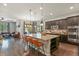 Gourmet kitchen with dark cabinets, a large island, granite countertops, and stainless steel appliances at 21376 E Union Pl, Aurora, CO 80015