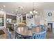 Open kitchen and dining area with dark wood floors and modern lighting fixtures at 21376 E Union Pl, Aurora, CO 80015