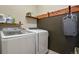 Modern laundry room featuring white Samsung washer and dryer, wood shelving and dark accent wall at 21376 E Union Pl, Aurora, CO 80015