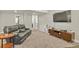 Spacious living room with plush carpet, leather sofa, and entertainment center with a TV at 21376 E Union Pl, Aurora, CO 80015