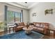 Comfortable living room featuring leather sofas, tray ceiling, and natural light at 21376 E Union Pl, Aurora, CO 80015
