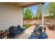 Inviting covered patio with comfortable seating, string lights, and a view of the beautifully landscaped backyard at 21376 E Union Pl, Aurora, CO 80015